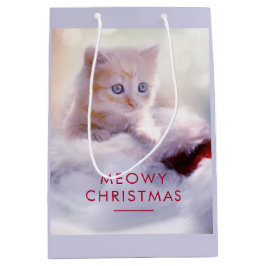 Niedliche Kittenruhe auf einer Weihnachtsmannmütze Mittlere Geschenktüte