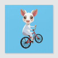 Niedliche, weiße Ziege auf dem Fahrrad