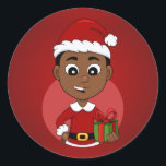 Niedlicher afrikanischer Weihnachtsjunge Cartoon Runder Aufkleber<br><div class="desc">Rundaufkleber mit einer Illustration eines niedlich lächelnden afroamerikanischen Jungen mit kurzem schwarzem Haar trägt der Junge ein Weihnachtskostüm mit einem roten Hut und hält ein Geschenk; in einem roten Kreis auf einem roten Hintergrund ein Weihnachtsferien-Design</div>