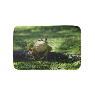 Niedlicher grüner Frosch schlägt eine Pose auf dem Badematte
