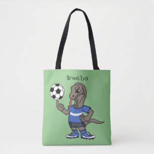 Niedlicher Komodo-Drache beim Fußballspielen Carto Tasche
