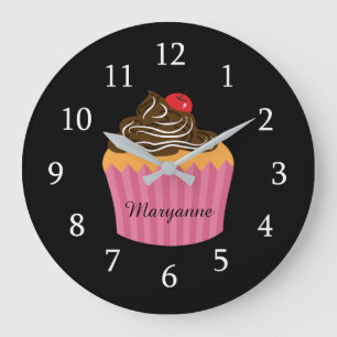 Niedlicher rosa kleiner Kuchen auf schwarzer Große Wanduhr