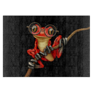 Niedlicher roter Baum-Frosch mit Augen-Gläsern au Schneidebrett