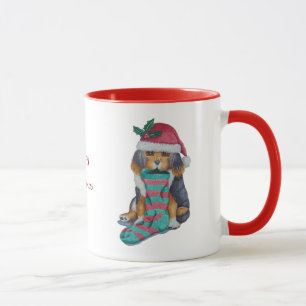 niedlicher schwarzer und brauner Welpe mit Tasse