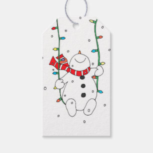 Niedlicher Snowman, der auf Weihnachtslichtern Geschenkanhänger