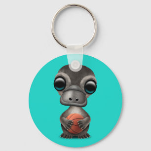 Niedliches Baby Platypus, der mit Basketball Schlüsselanhänger