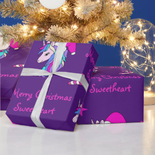 Niedliches Einhorn in rosa Weihnachtsmannmütze zu Geschenkpapier