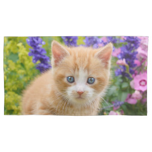 Niedliches Ingwer-Katzen-Kätzchen in blumigem Kissenbezug