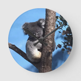 Niedliches Koala in einem Baum mit blauem Hintergr Runde Wanduhr