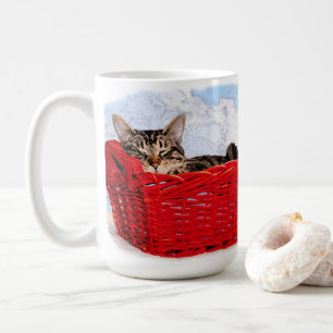 Niedliches Schlafkätzchen im hellen, roten Körbche Kaffeetasse