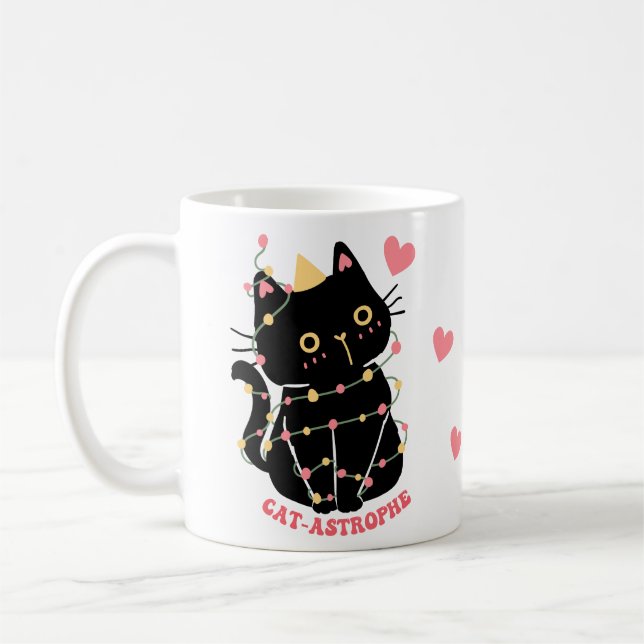 Niedliches schwarzes Kätzchen in Katzenkatastrophe Kaffeetasse (Links)