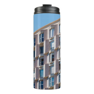 NIEDRIGES FOTO DES GRAUKONKRETEN GEBÄUDE THERMOSBECHER