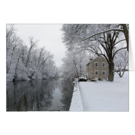 Noch Haus entlang ruhigem Wasser im Schnee