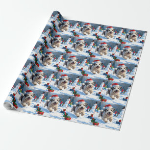 Old English Sheepdog läuft im Schnee mit Weihnacht Geschenkpapier