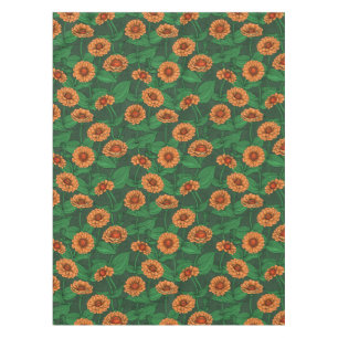 Orange Zinnia Blume, grüne Blätter auf dunkelgrün Tischdecke