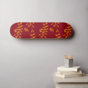Orangefarbene Blätter der Silhouette auf rot Skateboard