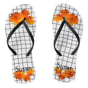 Orangefarbene Kosmos-Blume am Schwarzen Raster auf Flip Flops