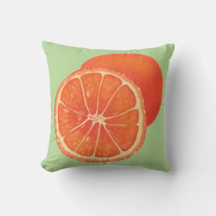 Orangefarbene und geschnittene Orangen auf grünen  Kissen