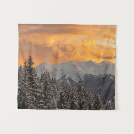Orangefarbene Wolken über Bergen und Fichtenwald Wandteppich