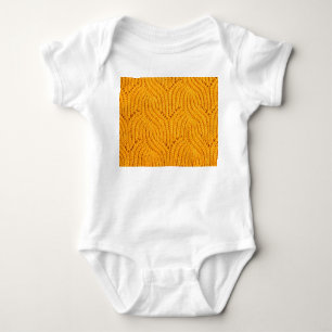 Orangefarbener Pullover, texturierter Hintergrund. Baby Strampler