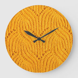 Orangefarbener Pullover, texturierter Hintergrund. Große Wanduhr