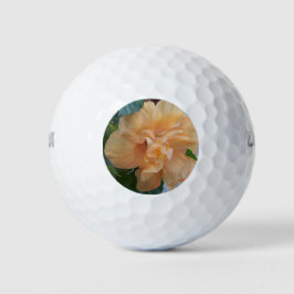 Orangene Hibiskusblüte auf einer goldenen Kugel Golfball