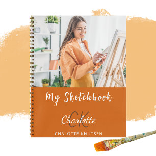 Orangenmonogramm des Sketchbook-Fotos Notizbuch