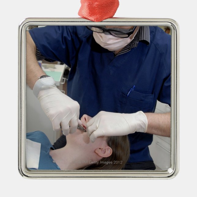 Orthodontist, der die zahnmedizinischen Klammern Silbernes Ornament (Vorne)