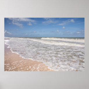 Ozean-Wellen, die den Sand auf dem Strand bedecken Poster