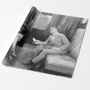Paar sitzt zusammen in einem Abteil eines Zuges Geschenkpapier