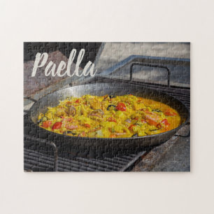 Paella wird auf einem Grillgeschenk für Koch gekoc
