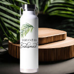 Palm Leaf Calligraphy Bridesmaid Trinkflasche<br><div class="desc">Brautparty Geschenk für Ihre Brautjungfrau - oder für jeden in Ihrer Hochzeitsfeier. Bridesmaid wird in Wirbler handgeschriebener Kalligrafie geschrieben und kann durch Eingabe des Designwerkzeugs leicht auf eine andere Rolle umgeschaltet werden. Das Design umfasst ein tropisches Palmenblatt in Aquarellfarbe, das auch im Monogramm-Motiv mit den Initialen, Namen und Hochzeitstag der...</div>