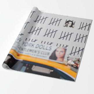 PAPIER CADEAU CAB JAUNE DEVANT UN MUR PEINT BLANC