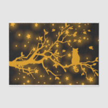 Chat étoilé de nuit sur une branche d'arbre