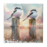 Pastel Watercolor Birds Fencepost Sunset Fliese<br><div class="desc">Soft watercolor brushwork captures two fluffy songbirds resting on weathered fence posts as a glowing sunset spreads across a dreamy countryside sky. Gentle washes of peach, blush pink, pale blue, and warm gold blend into a tranquil horizon, creating a calm pastoral atmosphere. The birds appear round and feathery, their delicate...</div>