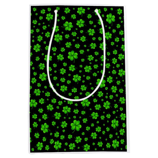 Pattern of green shamrocks on black background mittlere geschenktüte (Vorderseite)