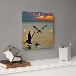 Pelikan starten bei Sonnenuntergang Golf Coast Flo Quadratische Wanduhr
