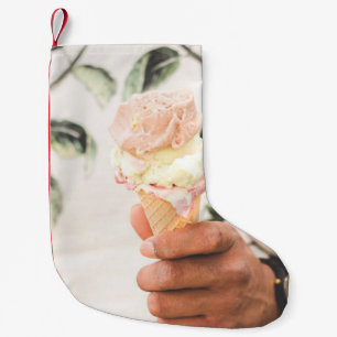 Person, die Eistüte mit drei Geschmacksrichtungen Kleiner Weihnachtsstrumpf