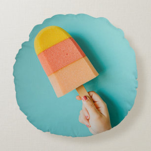 Person holding yellow and pink popsicle rundes kissen