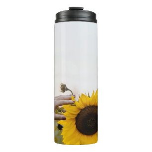 Person mit Sonnenblume Thermosbecher