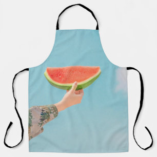 Person mit Wassermelone in Scheiben Schürze