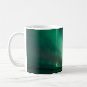PERSON STEHEND VOR AURORA-LICHTEN KAFFEETASSE