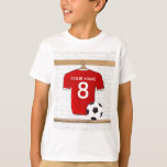 Personalisiert Red and White Football Soccer Jerse T-Shirt<br><div class="desc">Ein personalisiertes Fußballfußball-Trikot in Rot mit weißem Trimm, das in einem Sportraum mit Wasserflasche, Fußball und Fußball hängt. Fügen Sie einfach den Namen und die Nummer (oder das Alter) des Fußballspielers, Fußballfans oder Fußballmannschaftstrainers hinzu, um ein einzigartiges Fußballgeschenk zu schaffen. Andere Fußball-Mannschaftsfarben sind in unserem Shop erhältlich und wir freuen...</div>