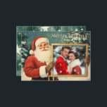 Personalisierte Vintage Weihnachtskarte Feiertagskarte<br><div class="desc">Diese Weihnachtskarte zeigt einen klassischen, Vintagen Weihnachtsmann, der ein gerahmtes Foto in Gold aufbewahrt, um Ihr wertvolles in der Familie einzufügen. Der fröhliche Ausdruck des Weihnachtsmannes und die verschneite Kulisse schaffen ein warmes, nostalgisches Urlaubsstimmung. Über dem Rahmen steht "Frohe Weihnachten!" in einem spielerisch weißen Drehbuch, und Ihr Familienname erlaubt es,...</div>