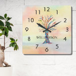 Personalisierter Regenbogenbaum Quadratische Wanduhr<br><div class="desc">Diese farbenfrohe Wall Clock ist mit einem Mosaik-Stammbaum in den Farben des Regenbogens auf einem Aquarellgrund geschmückt. Einfach mit Ihrem Namen anpassbar. Weil wir unsere eigenen Kunstwerke erstellen,  werden Sie dieses exakte Bild von anderen Designern nicht finden. Original Mosaik und Wasserfarbe © Michele Davies.</div>