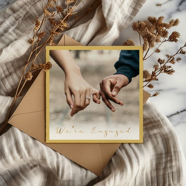 Photo de l'écriture d'or engagé faire-part (A thin border. "We're Engaged" written in a modern gold effect script and photo)