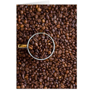 Pile de haricots de café avec la coupe de café ple