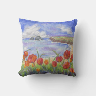 Plage avec le coussin de carré de pavots