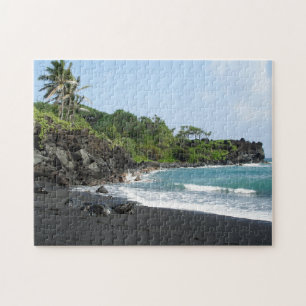 Plage noire de sable sur le puzzle denteux d'Hawa