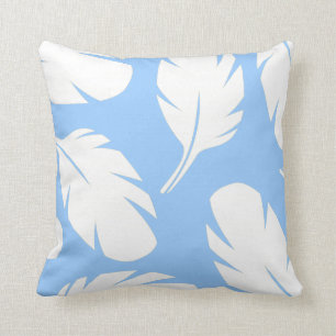 Plumes blanches sur oreiller bleu clair